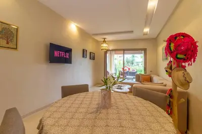 a dining room with a table and a living room at Charming apartment with a garden in Marrakech