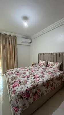 a bed with a floral comforter in a bedroom at Appartement de luxe en plein centre à Marrakech in Marrakech