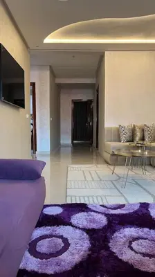 a living room with a purple couch and a rug at Appartement de luxe en plein centre à Marrakech in Marrakech