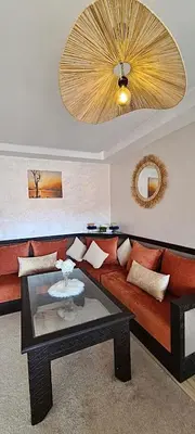 a living room with a red couch and a mirror at Appartement 2 Chambre au Coeur de gueliz Marrakech in Marrakech