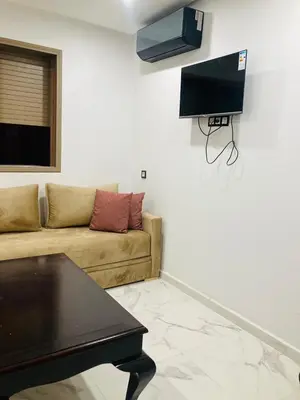 a living room with a couch and a tv on the wall at Magnifique appartement à Marrakech in Marrakech