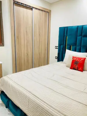 a bedroom with a large white bed with red pillows at Magnifique appartement à Marrakech in Marrakech
