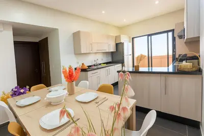 a kitchen and dining room with a table and chairs at Luxurious M avenue Hivernage - next to Pestana CR7 in Marrakech
