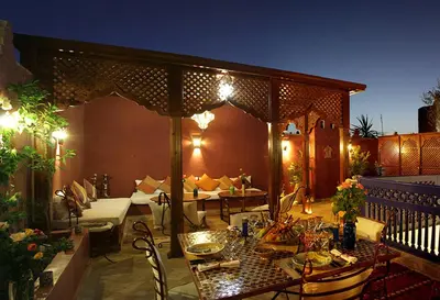 an outdoor patio with a table and chairs and an umbrella at Riad Dar Colline in Marrakech