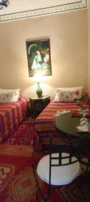 a room with two beds and a table with a lamp at Riad Dar Colline in Marrakech