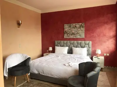 a bedroom with a large bed and a chair at Lot tichka villa n6 in Marrakech