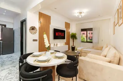 a living room with a couch and a table and chairs at Oasis exclusive avec piscine dans le centre-ville in Marrakech