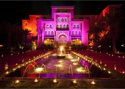 a pink building with a fountain in front of it at Oasis exclusive avec piscine dans le centre-ville in Marrakech