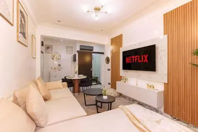 a living room with a white couch and a tv at Oasis exclusive avec piscine dans le centre-ville in Marrakech