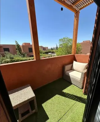 a screened in porch with a chair and a bench at Charmant villa au cœur de la palmeraie in Douar Caïd Layadi
