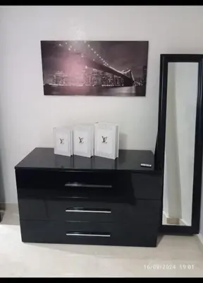 a black dresser with two boxes on it in front of a mirror at Chic et Cosy deux chambres avec Piscine in Marrakech