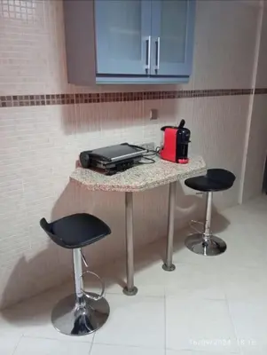 a kitchen with two stools and a counter with a appliance at Chic et Cosy deux chambres avec Piscine in Marrakech