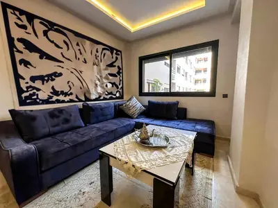 a living room with a blue couch and a table at HIVER NAGE home in Marrakech