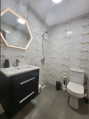 a bathroom with a toilet and a sink and a mirror at HIVER NAGE home in Marrakech