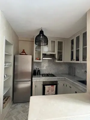 a kitchen with a stainless steel refrigerator and white cabinets at Riad dar Tayri in Marrakech