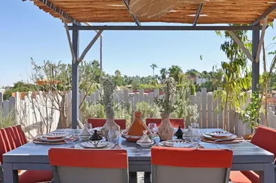 a blue table with red chairs and vases on it at Riad dar Tayri in Marrakech