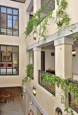 an internal courtyard of a building with plants at Riad dar Tayri in Marrakech