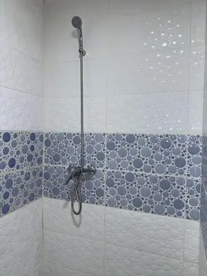 a shower in a bathroom with blue and white tiles at Appartement Xénon in Marrakech