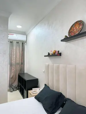 a bedroom with a bed and a black night stand at Appartement Xénon in Marrakech