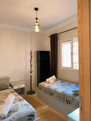 a bedroom with two beds and a window at Appartement Xénon in Marrakech