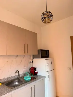 a kitchen with a sink and a refrigerator at Appartement Xénon in Marrakech