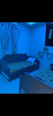 two beds in a room with a blue light at Marrakech Les portes de gueliz 2 immeuble 4 appartement 29 in Marrakech