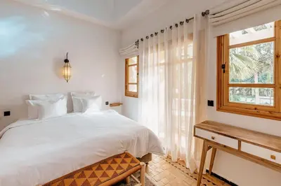 a bedroom with a white bed and a window at La Villa d'Oz pour 12 personnes Golf Amelkis in Marrakech