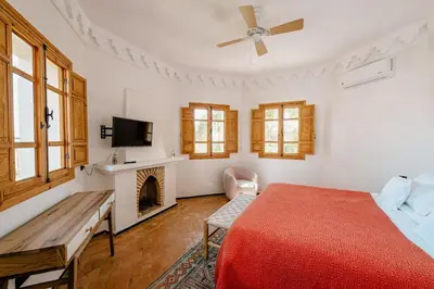 a bedroom with a red bed and a fireplace at La Villa d'Oz pour 12 personnes Golf Amelkis in Marrakech
