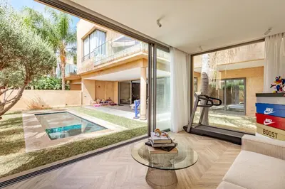 a living room with a large glass window and a pool at New! Appt de Luxe à Oliver Palm, Piscine Privé in Marrakech