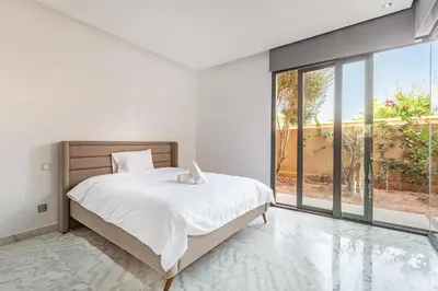 a bedroom with a bed and a large window at New! Appt de Luxe à Oliver Palm, Piscine Privé in Marrakech