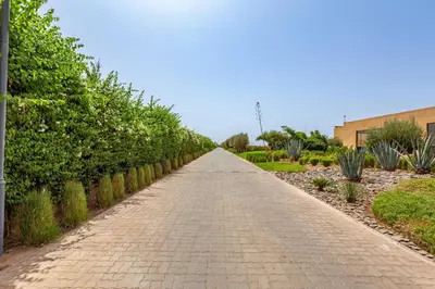 a brick road in a garden with bushes at New! Appt de Luxe à Oliver Palm, Piscine Privé in Marrakech