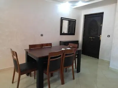 a dining room with a table and chairs and a door at Appartement avec piscine Guéliz in Marrakech