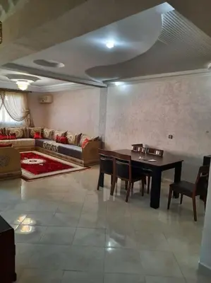 a living room with a table and a couch at Appartement avec piscine Guéliz in Marrakech