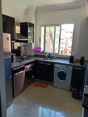 a kitchen with a sink and a washing machine at Appartement avec piscine Guéliz in Marrakech