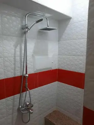 a shower in a bathroom with red and white tiles at Appartement avec piscine Guéliz in Marrakech