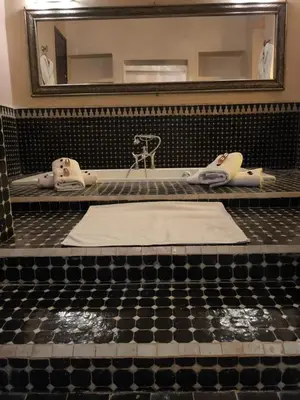 a bathroom with a bath tub and a mirror at Riad shéhérazade Marrakech in Marrakech
