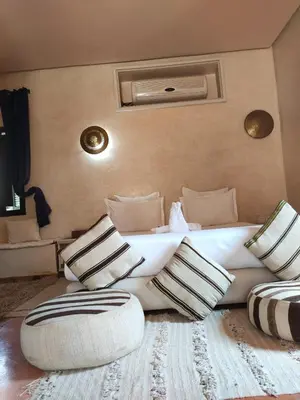a living room with a large white couch and pillows at Riad shéhérazade Marrakech in Marrakech