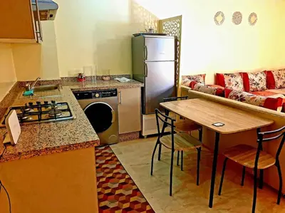 a kitchen with a refrigerator and a table and a couch at Séjour spacieux à Marrakech in Marrakech