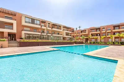 a swimming pool in front of a building at New! Appt Riad Garden, piscine & wifi & parking in Marrakech