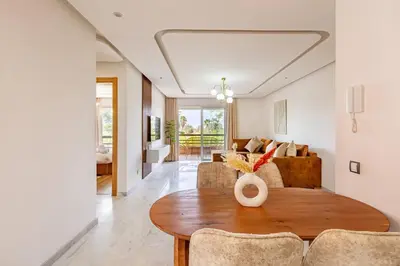 a living room with a table and a couch at New! Appt Riad Garden, piscine & wifi & parking in Marrakech