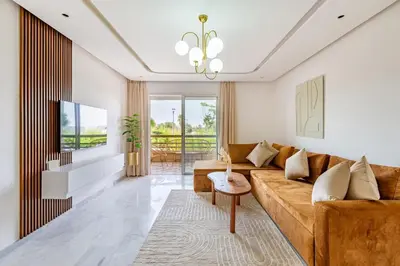 a living room with a couch and a tv at New! Appt Riad Garden, piscine & wifi & parking in Marrakech