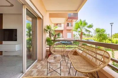 a balcony with two chairs and a television on a balcony at New! Appt Riad Garden, piscine & wifi & parking in Marrakech