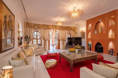 a living room with a table and a fireplace at Villa 5 suits with pool and montains view in Sraghna