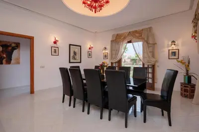 a dining room with a black table and black chairs at Villa 5 suits with pool and montains view in Sraghna