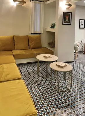 a living room with a couch and two tables at Riad Dardeco privé centre Medina Marrakech in Marrakech