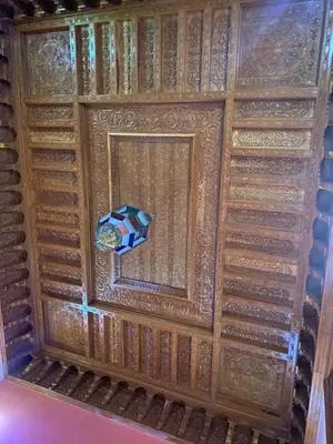 a room with a wooden wall with a window at Riad Tichka piscine palmeraie in Marrakech