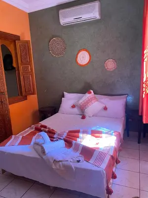a bedroom with a bed with blankets and pillows at Riad Tichka piscine palmeraie in Marrakech