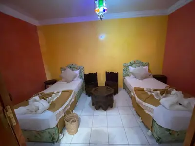 a room with two beds with towels on them at Riad Tichka piscine palmeraie in Marrakech