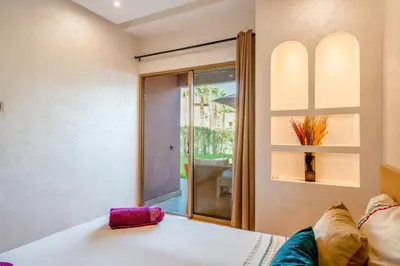 a bedroom with a bed and a sliding glass door at Relax Front of Pool - Golf- Fiber Optic in Marrakech