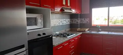 a kitchen with red cabinets and a microwave at dar rita in Marrakech